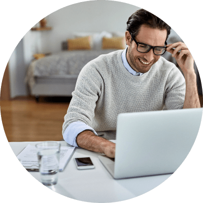 Happy freelance professional working on laptop, Microsoft Access modernization services.